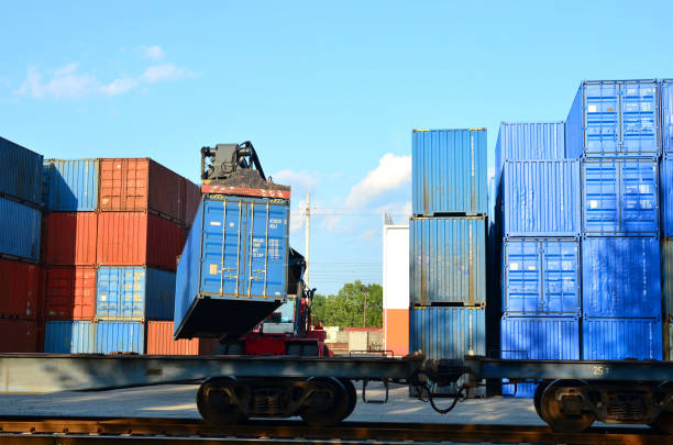 Shipping container loading by richtracker on the freight rail car at logistic warehouse port. Ocean Freight Cargo Shipping, Intermodal Container Freight concept