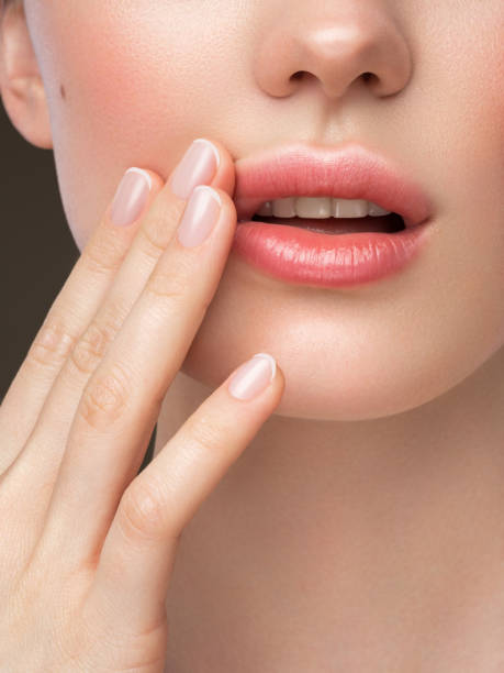 Part of woman's face. Woman's lips, nose and hand. Soft skin. Part of woman's face. Woman's lips, nose and hand. Soft skin. human lips stock pictures, royalty-free photos & images