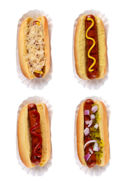 istock Four different hotdogs on paper holders with different condiment toppings isolated on white. 1283391484