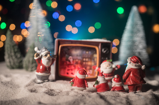 Creative Christmas concept. Vintage television set on snow with Santa Claus. Artwork decoration.