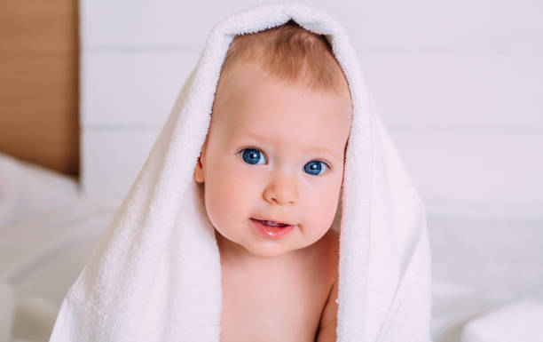 istock Cute baby with blue eyes wrapped in a white towel. 1283392571