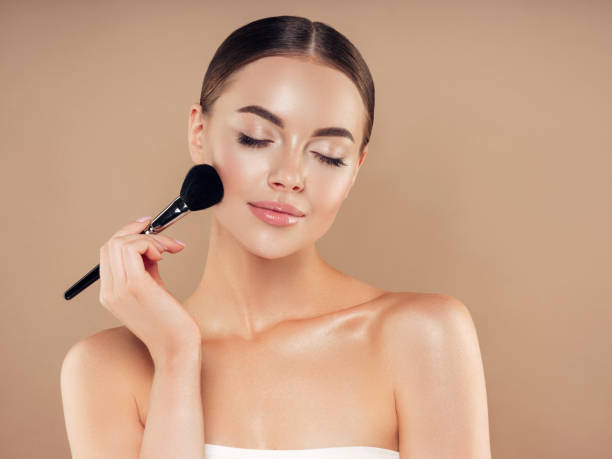 Beautiful young woman applying foundation powder Beautiful young woman applying foundation powder stage make up stock pictures, royalty-free photos & images