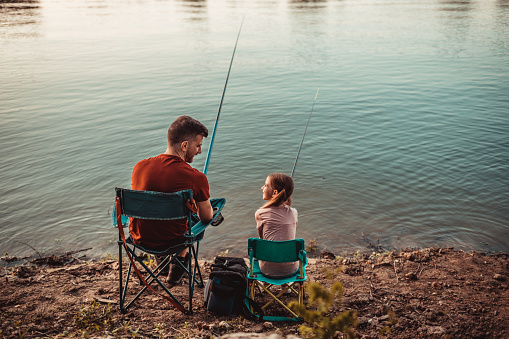 Mother and daughter fishing in lake