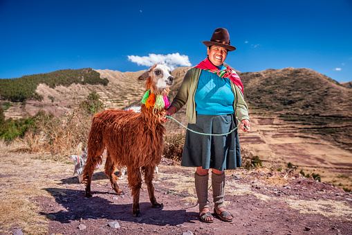 Peruvian woman wearing national clothing posing with llama near Cuzco. The Sacred Valley of the Incas or Urubamba Valley is a valley in the Andes  of Peru, close to the Inca capital of Cusco and below the ancient sacred city of Machu Picchu. The valley is generally understood to include everything between Pisac  and Ollantaytambo, parallel to the Urubamba River, or Vilcanota River or Wilcamayu, as this Sacred river is called when passing through the valley. It is fed by numerous rivers which descend through adjoining valleys and gorges, and contains numerous archaeological remains and villages. The valley was appreciated by the Incas due to its special geographical and climatic qualities. It was one of the empire's main points for the extraction of natural wealth, and the best place for maize production in Peru.