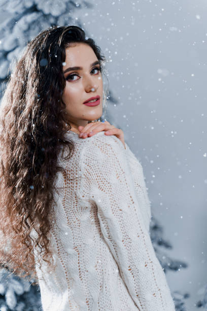 istock New year celebration.Happy girl with falling snow. Young woman weared in a warm white pullover and white socks. Winter holidays in snowy day 1283400189