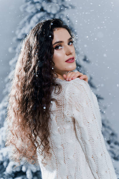 istock New year celebration.Happy girl with falling snow. Young woman weared in a warm white pullover and white socks. Winter holidays in snowy day 1283400210