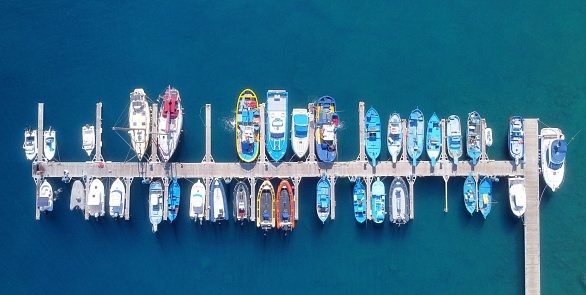 Panoramic Aerial view on boats moored in the pier, drone shot directly above. High quality photo