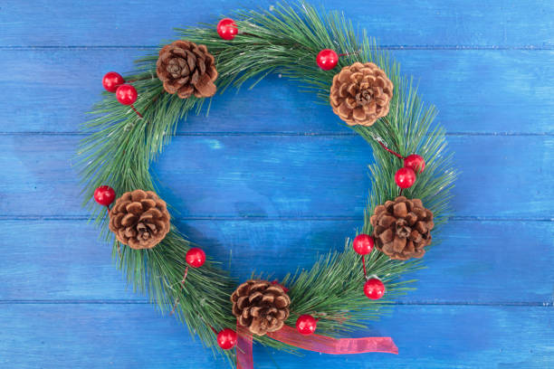 istock Christmas wreath decoration on blue wooden background 1283401158