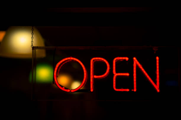 istock Open neon sign in red hanging in shop window at night 1283402011
