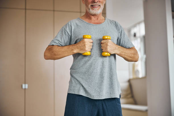 istock Active senior gentleman doing a workout with dumbbells at home 1283402165