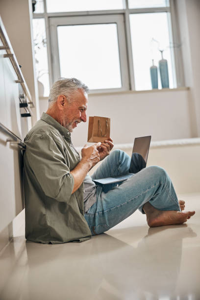 istock Smiley aged gentleman unpacking gift via a video call 1283402189