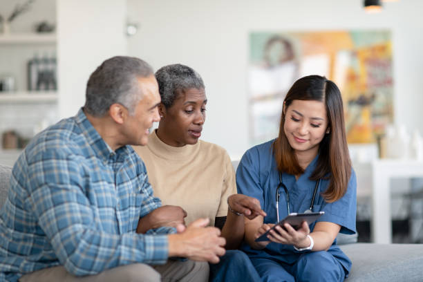 istock Visiting nurse meets with senior couple 1283408827