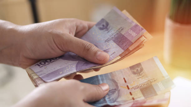nahaufnahme einer person, die geld zählt, uang indonesische rupiah - indonesian currency stock-fotos und bilder