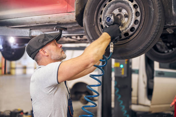 istock Bearded auto mechanic repairing car wheel disk in garage 1283410003