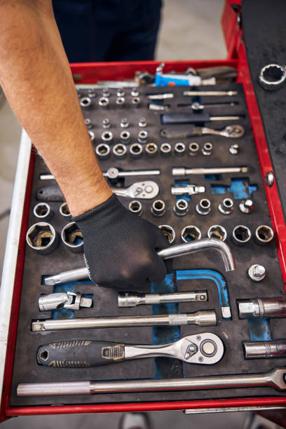 istock Auto mechanic grabbing curved rod wrench from vehicle tools box 1283410006