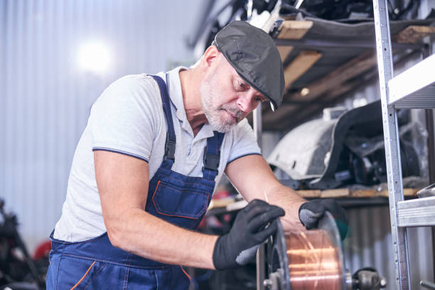 istock Bearded mechanic using copper wire at repair service station 1283411683
