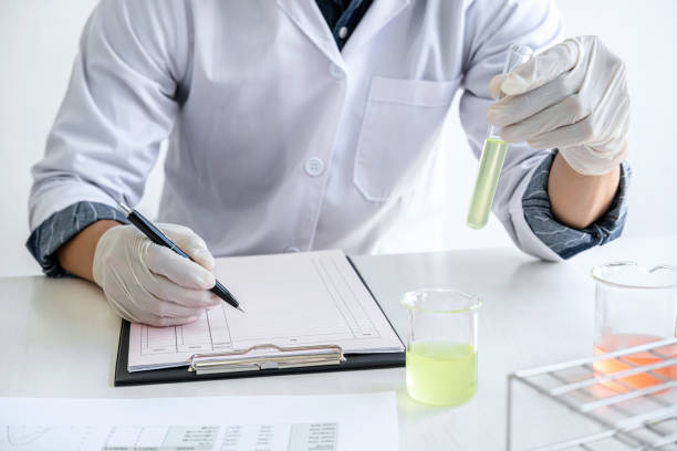 istock Biochemistry laboratory research, Chemist is analyzing sample in laboratory with equipment and science experiments glassware containing chemical liquid 1283414303
