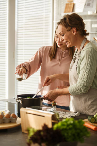istock Mother and daughter having fun cooking lunch together 1283414622