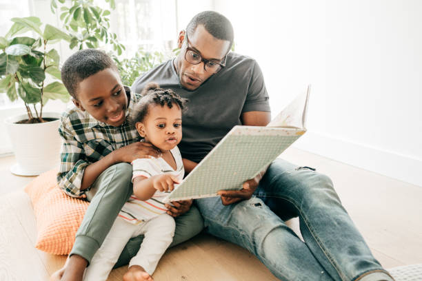 istock Dad reading a book with kids sitting on the kitchen floor 1283414629