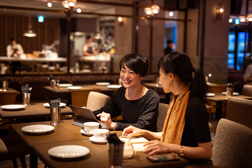 Japanese women having business discussion in elegant cafe