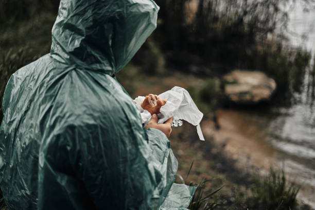 a man with a beard in a green raincoat eats in nature. cloudy weather, fast food. - 11321 imagens e fotografias de stock