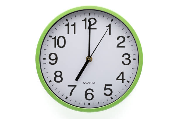istock Clipping path included. Clock on white background showing seven o'clock. 1283414749