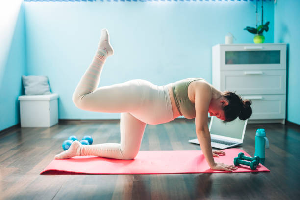 junge und schöne schwangere frau übungen zu hause - human pregnancy exercising relaxation exercise sport stock-fotos und bilder