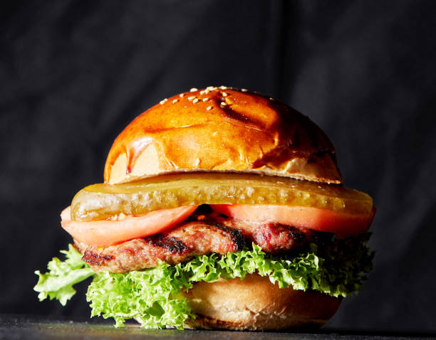 istock Fresh tasty burger on dark background 1283416643