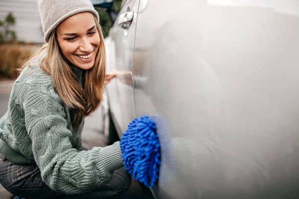 istock Women rubbing car with wipe cloth 1283417701