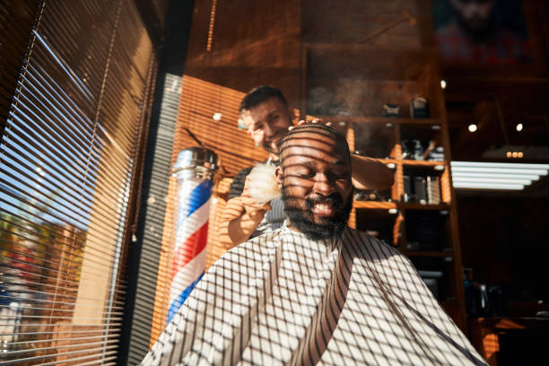 istock Cheerful barber applying talcum powder on client neck 1283421549