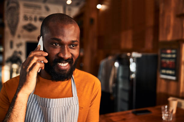 istock Cheerful Afro American man talking on cellphone at work 1283421567
