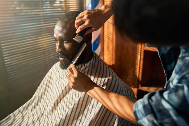 istock Male barber shaving client beard in barbershop 1283421646