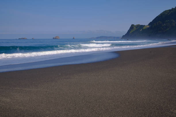 istock Early morning sun catches waves.  Humbug Mountain State Park beach. 1283426281