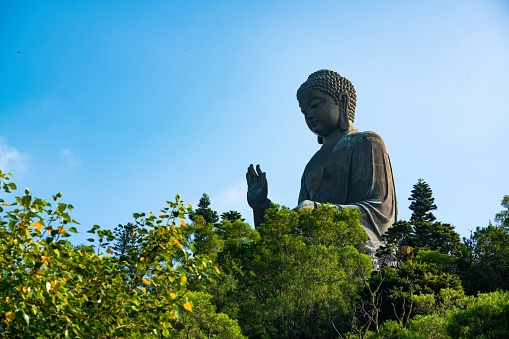 A vertical shot of seated stone Buddha statue in the park
