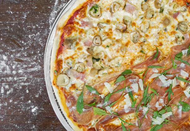 istock Closeup Two Flavors Italian Pizza on Wooden Table 1283434565