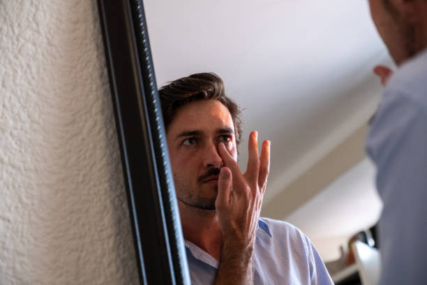istock Gay man sits puts cream on his face 1283434601