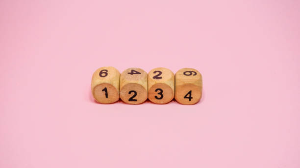 istock Wooden dice on pink background 1283436334