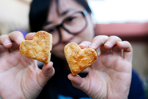 girl holding handmade heart shape biscuit