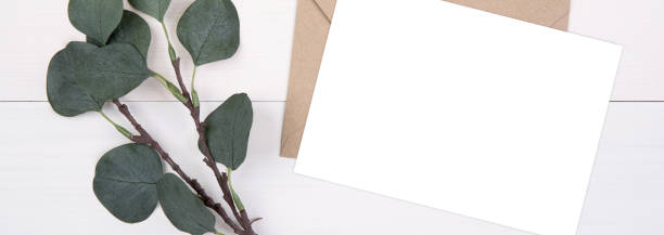 istock Blank paper sheet copy space with mockup and leaf on wooden table, card, poster and envelope, postcard decoration your design or branding, simplicity and minimal, flat lay, top view, banner website. 1283437150