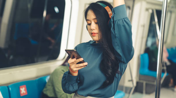 istock Young woman using mobile phone on public train 1283437837
