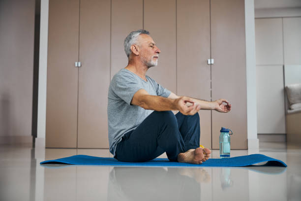 istock Relaxed aged gentleman doing meditation at home 1283438844