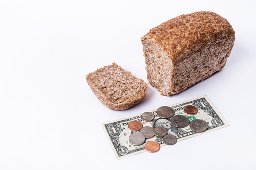 Healthy coarse bread, one American dollar bill and American bargaining chips on white background