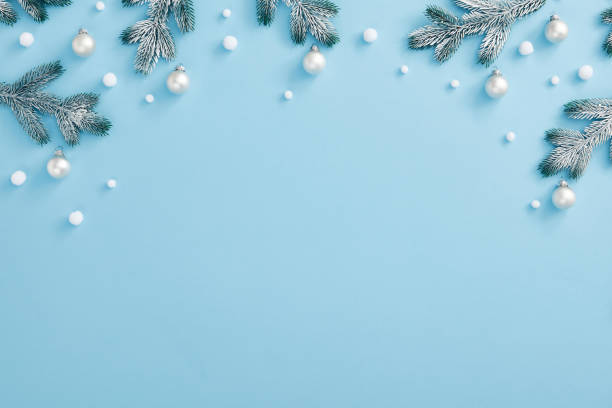 istock Christmas composition with snowy fir branch and white bauble. Horizontal top composition, flat lay, view from above. Pastel blue background with copy space 1283441321