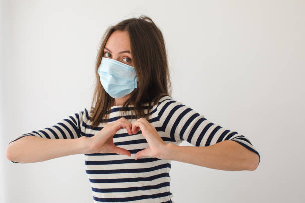 istock Female in mask gesturing heart 1283441474