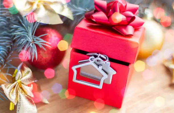 Keychain in the form of a house in a gift box. The concept of real estate as a gift. Christmas and New year.