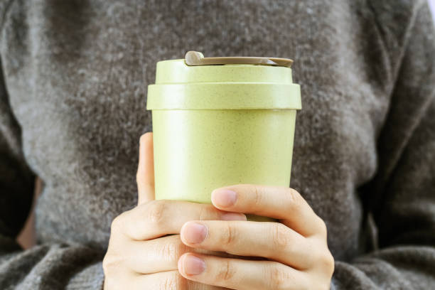 istock Girl holds in her hands reusable eco coffee cup. Zero waste concept. Ban single use plastic. Take away big mug for drinks. 1283445086
