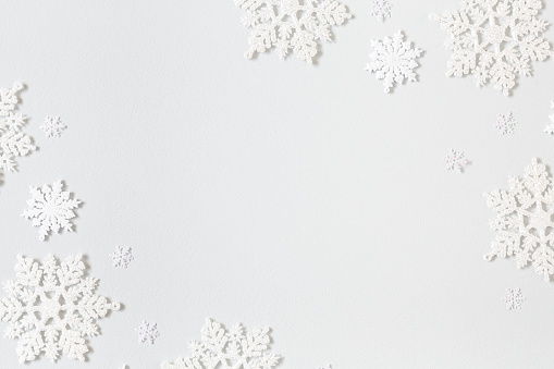 Composición navideña. Marco de copos de nieve sobre fondo gris pastel. Concepto de Navidad, invierno, Año Nuevo. Plano laico, vista superior photo