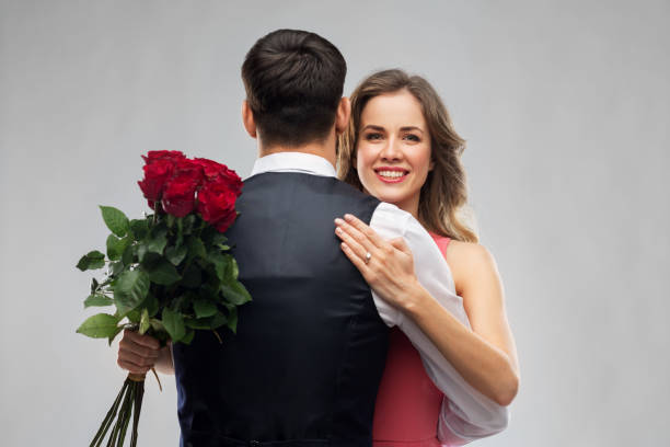 istock woman with engagement ring and roses hugging man 1283451286