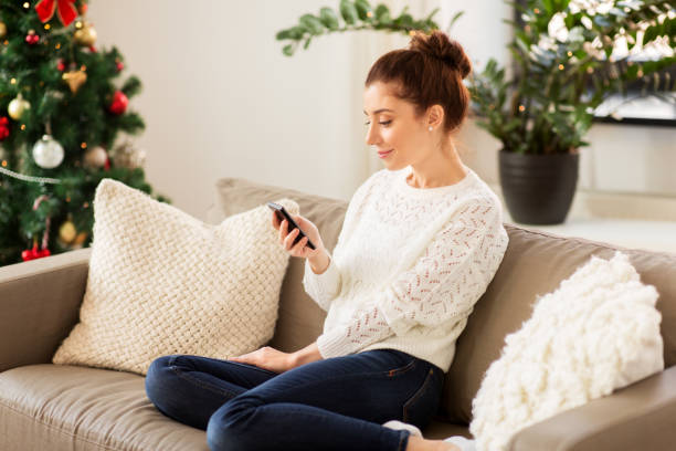istock woman with smartphone at home on christmas 1283451365