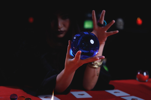 Fortune teller forecast future event or destiny by using blue crystal ball.